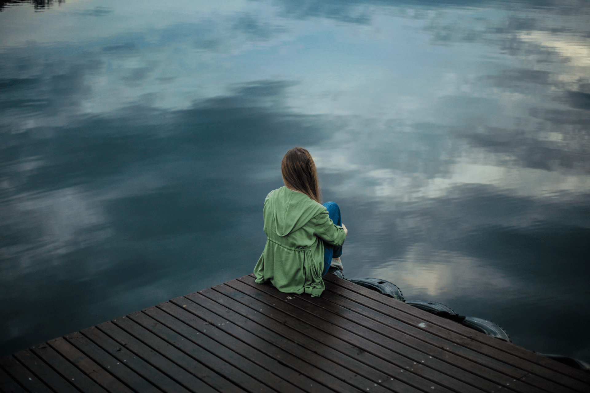 signs of deep emotional trauma a girl sitting in looking at the water